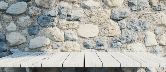 Poster - Empty white wooden table with textured stone wall background suitable for product displays and presentations in modern decor settings.