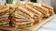 © Giovanni - Assorted gourmet sandwiches arranged neatly on a wooden platter ready for a delicious meal or catering event.