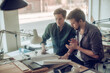 © Geber86 - Two young men working on a project together in a startup company office