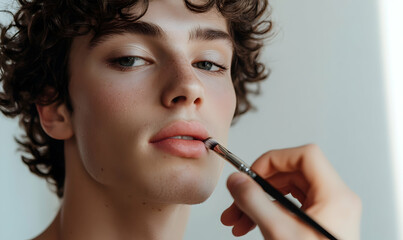 closeup of a casual young man with dramatic makeup fixing his hair while looking at the camera