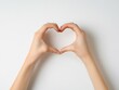 © Arham - Hands forming a heart shape, displayed on a white background,