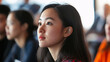 © Anastasia - A close-up of an Asian woman attentively listening, showcasing her focused expression and natural beauty in a bright, engaging setting