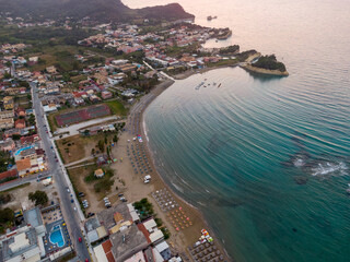 Wall Mural - Aerial view of coastal town at sunset, with beach, calm sea, and buildings.