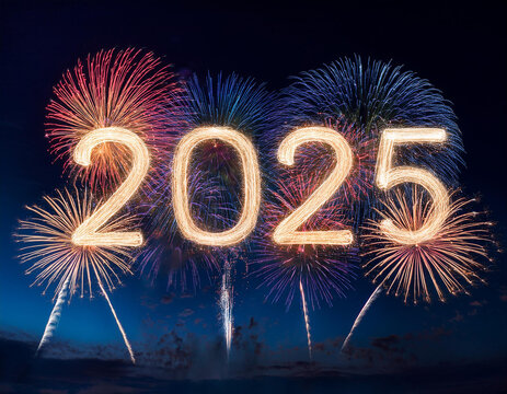 Fireworks explosions in the shape of 2025. Against the background of dark sky.