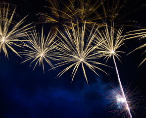 Wall Mural - Golden firework sparkling on blue sky with smoke