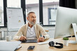 © LIGHTFIELD STUDIOS - Senior man in casual attire focused on digital work at his stylish home office workspace