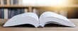 © Sufee - Library quiet reference concept. Open book resting on a wooden table, with blurred shelves in the background, illuminated by soft sunlight.