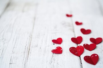 Wall Mural - A collection of red hearts scattered across a white wooden table, perfect for romantic gestures or Valentine's Day decor