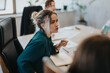 © qunica.com - A business meeting in a modern office showing a focused woman engaging in a discussion. The environment is multicultural and collaborative, emphasizing teamwork and innovation among business people.