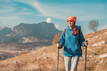 young hiker woman walking in mountain landscape on sunny autumn day