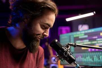 Poster - Music composer singing his new lyrics on microphone in home studio, producing soundtracks with daw software interface on pc. Male artist composing new melody with mixing console. Close up.