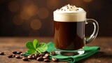 A delicious Irish coffee drink is displayed in a clear glass mug, sitting on a green napkin, accompanied by coffee beans and a four-leaf clover. Concept of an Irish coffee drink.
