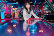 © ADDICTIVE STOCK - Asian Gen Z Girl Enjoying Arcade Experience in Neon Lights