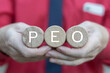 © wladimir1804 - PEO Professional Employer Organization Business Concept. Business person holding wooden blocks sees acronym: PEO. HR Human Resources Management.