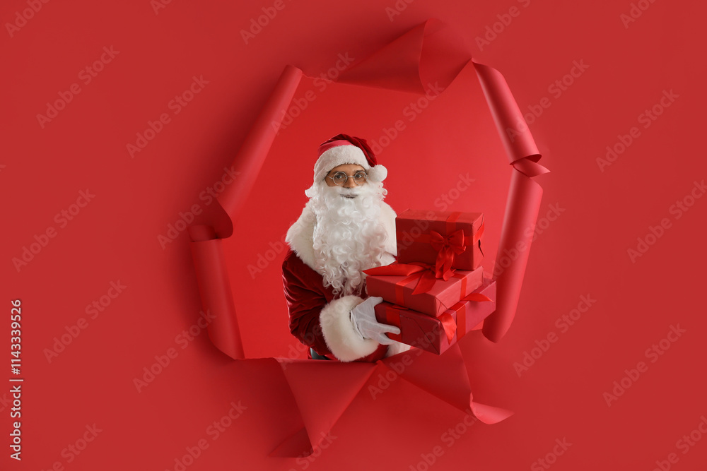 Santa Claus with gifts visible through hole in red paper