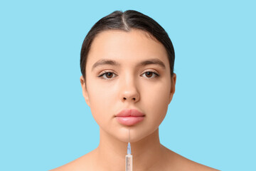 Sticker - Young woman receiving filler injection in lips on blue background