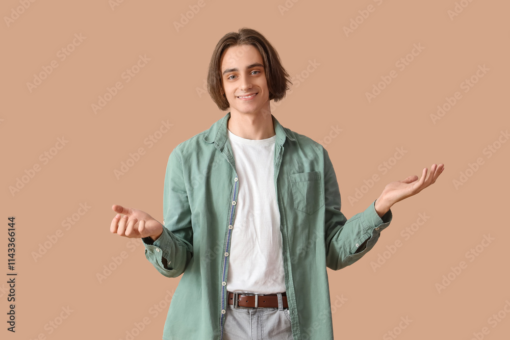 Young man smiling on beige background