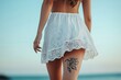 © Space Priest - A woman with a tattoo on her leg is walking on the beach