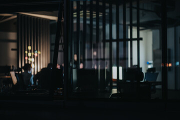 Wall Mural - A group of multiracial colleagues collaborate in a softly lit office, discussing projects and strategies at night. The atmosphere suggests focus, teamwork, and meeting tight deadlines.