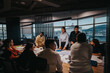 © qunica.com - A diverse group of business colleagues engaged in an intensive brainstorming session, exchanging ideas and analyzing plans in a modern, well-lit office environment. Multicultural teamwork for