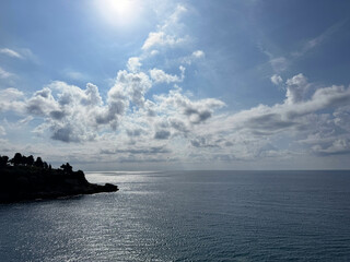 Shiny blue sea and scenic sky clouds horizon.