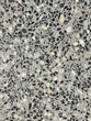 © Pannatat - Polished terrazzo surface with a mix of black, white, and gray stone fragments, creating a seamless and modern texture.