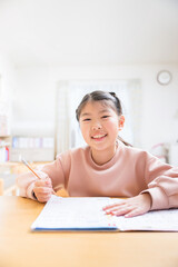 Poster - カメラ目線で笑顔で勉強をする小学生の女の子