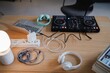 © Studio Marmellata - DJ controller, laptop, headphones, and various cables are neatly arranged on a wooden table in a cozy home studio, showing a creative and modern music production workspace.