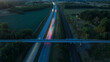 © Johnér - Drone view of bridge above two lane illuminated highway amidst agricultural field at dusk