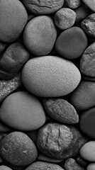 Poster - Smooth pebbles of various shapes and textures arranged on a dark surface during a tranquil afternoon