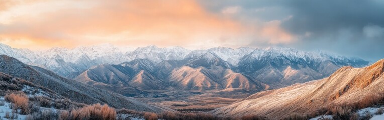 Poster - Snowy mountain range under orange and blue sky at sunset with valleys and peaks visible in breathtaking landscape