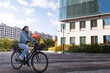 © Johnér - Young woman riding bicycle on city street