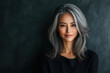 © TP71 - Beautiful woman with gray hair and a black top, set against a dark background. The concept allows for ample copy space. Manager in a startup company.