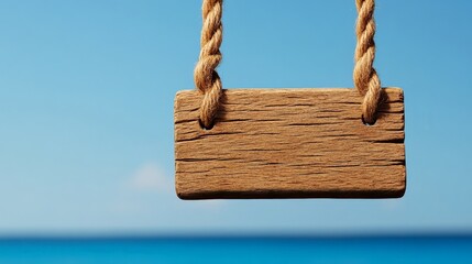 wooden signboard hanging by ropes against ocean: a rustic, weathered wooden signboard hangs from thi