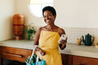 © (JLco) Julia Amaral - Smiling woman holding vegetable bag in brazilian kitchen