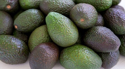 Poster - Freshly harvested avocados arranged in a flat lay setting showcasing their rich textures and colors on a neutral background.