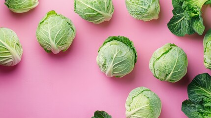 Poster - Fresh green cabbages arranged attractively on a vibrant pink background showcasing their texture and freshness in a colorful display