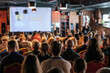 © Anton Gvozdikov - An audience gathered in a conference setting, engaged in a presentation. The space showcases professional and learning themes with focused participants and modern indoor decor.