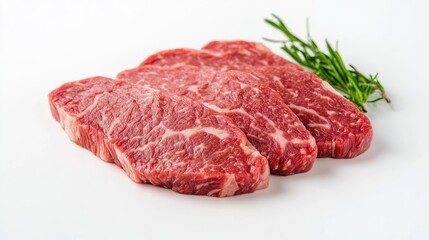 Poster - Freshly sliced marbled beef steaks on a clean white surface with a sprig of rosemary for culinary presentations and recipes