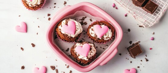 Aufkleber - Heart shaped pink cake and chocolate muffins in a basket Concept of baking with love Sweet treats on a light background from above