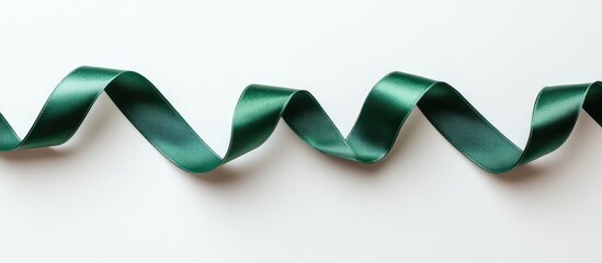 Poster - Elegant emerald green satin ribbon gracefully twisted on a clean white background perfect for holiday and gift decoration concepts.