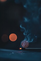 Poster - Smoking incense stick with bokeh lights in dark background.