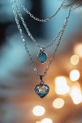 Aufkleber - Three layered silver necklaces with blue heart and circular pendants.