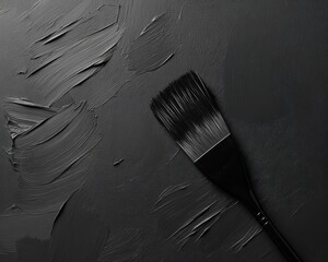 A close-up of a painter's brush on a dark textured surface, showcasing paint strokes and artistic tools.