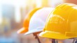 © tashechka - Brightly colored hard hats are lined up, ready for workers at a busy construction site, emphasizing safety in the building process