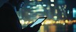 © fourtakig - Businessman typing on tablet with city skyline bokeh view at night