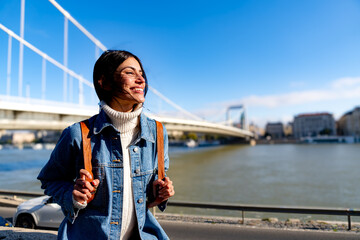 Wall Mural - A happy woman enjoying the moment, smiling and looking out at the view on a beautiful, sunny day. Copy space