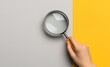 © The - Man hand with magnifying glass. Yellow ray coming from loupe. Conducting check, information search and analysis concept. Spy, accountant, auditor job in abstract style. High quality