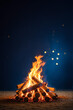 © Lisa - A burning bonfire on a dark blue background at night for Happy Lohri holiday or Punjabi festival. Traditional Indian festival. Backdrop for Bonfire Night festivities banner or poster with copy space.