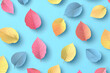 © mbah - Colorful paper leaves scattered on a blue background, creating a vibrant, decorative pattern.